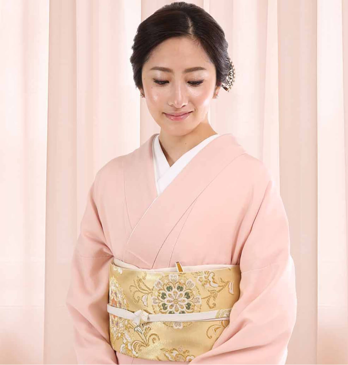 薄ピンクの色留袖を着た女性